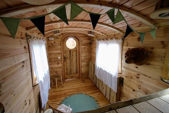 Porte cintrée de la roulotte avec son oeil de boeuf. 